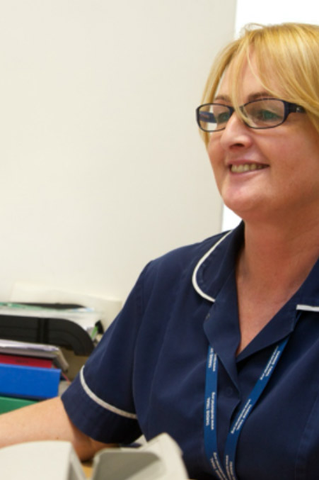 Picture of a smiling nurse working at a desk